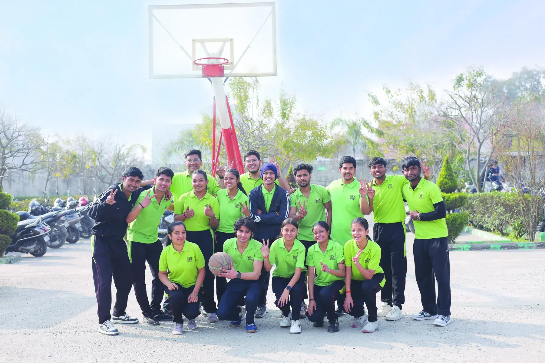 The HEC sports team in green jerseys on the basketball court