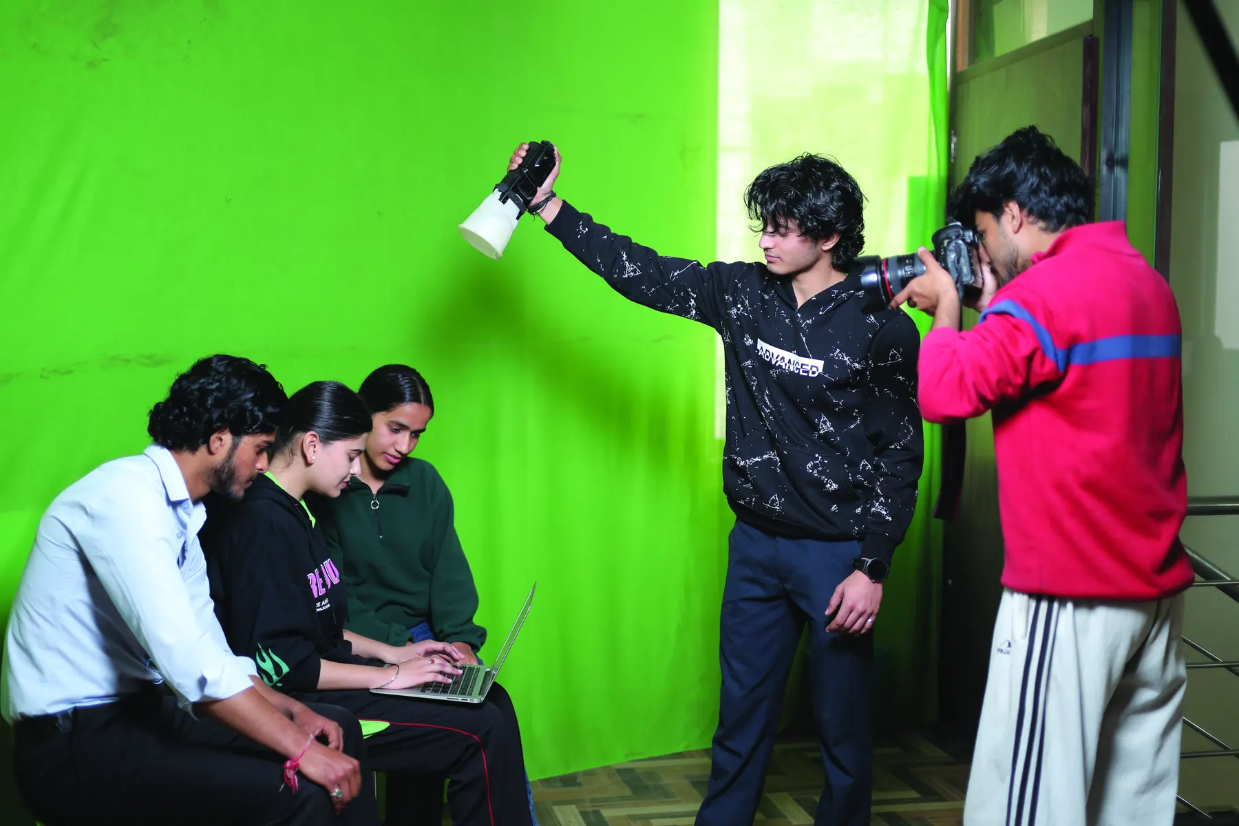 Students shooting against a green screen in the animation studio