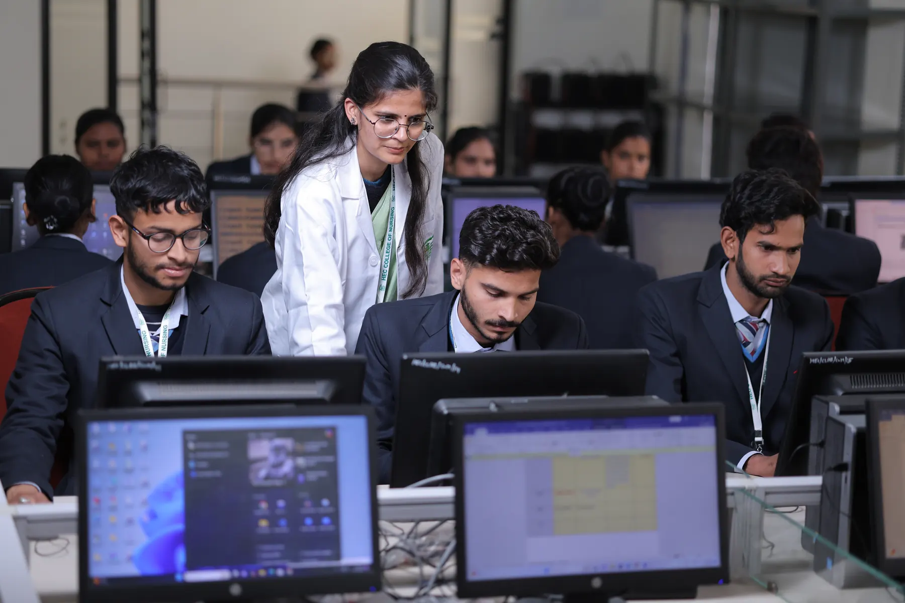 Students working at computers with a faculty member
