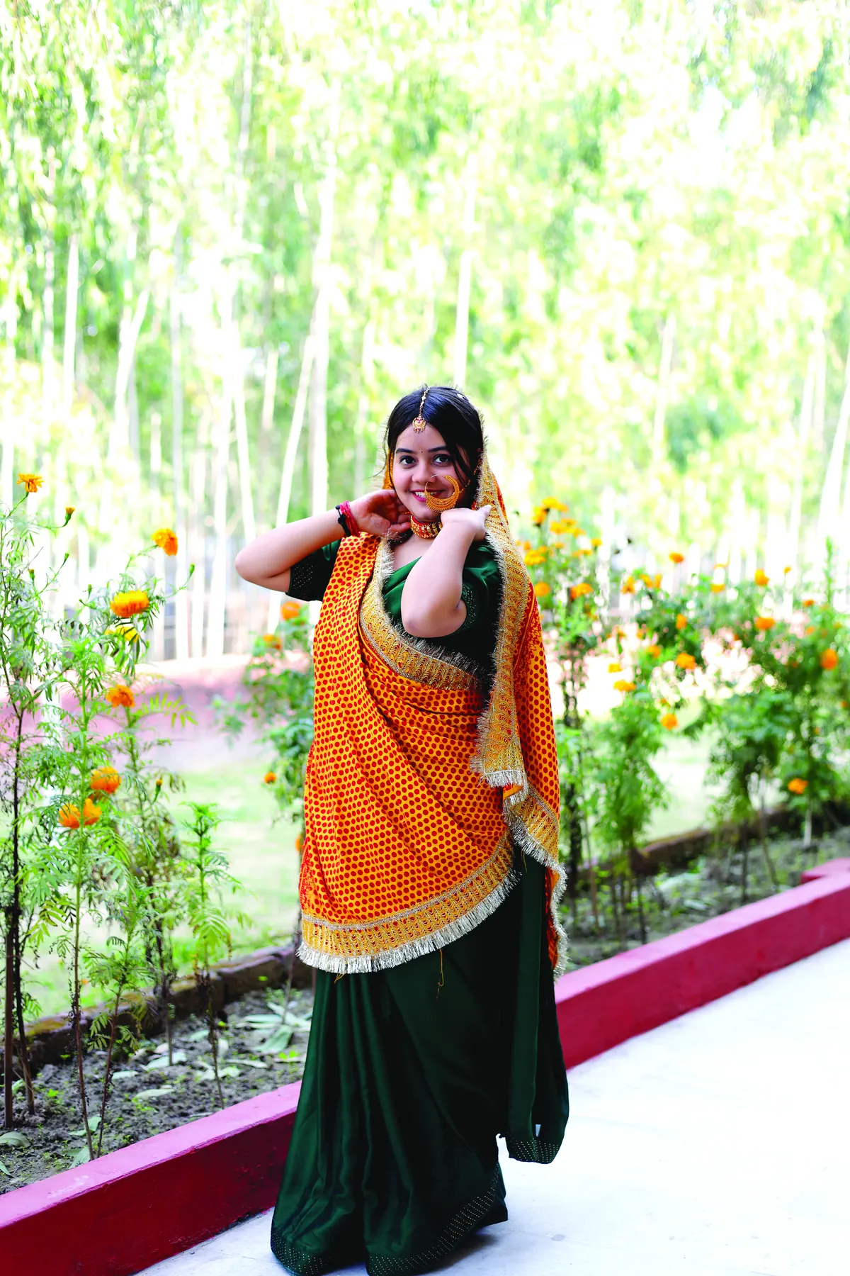 A student in traditional Garhwali attire among marigolds on campus