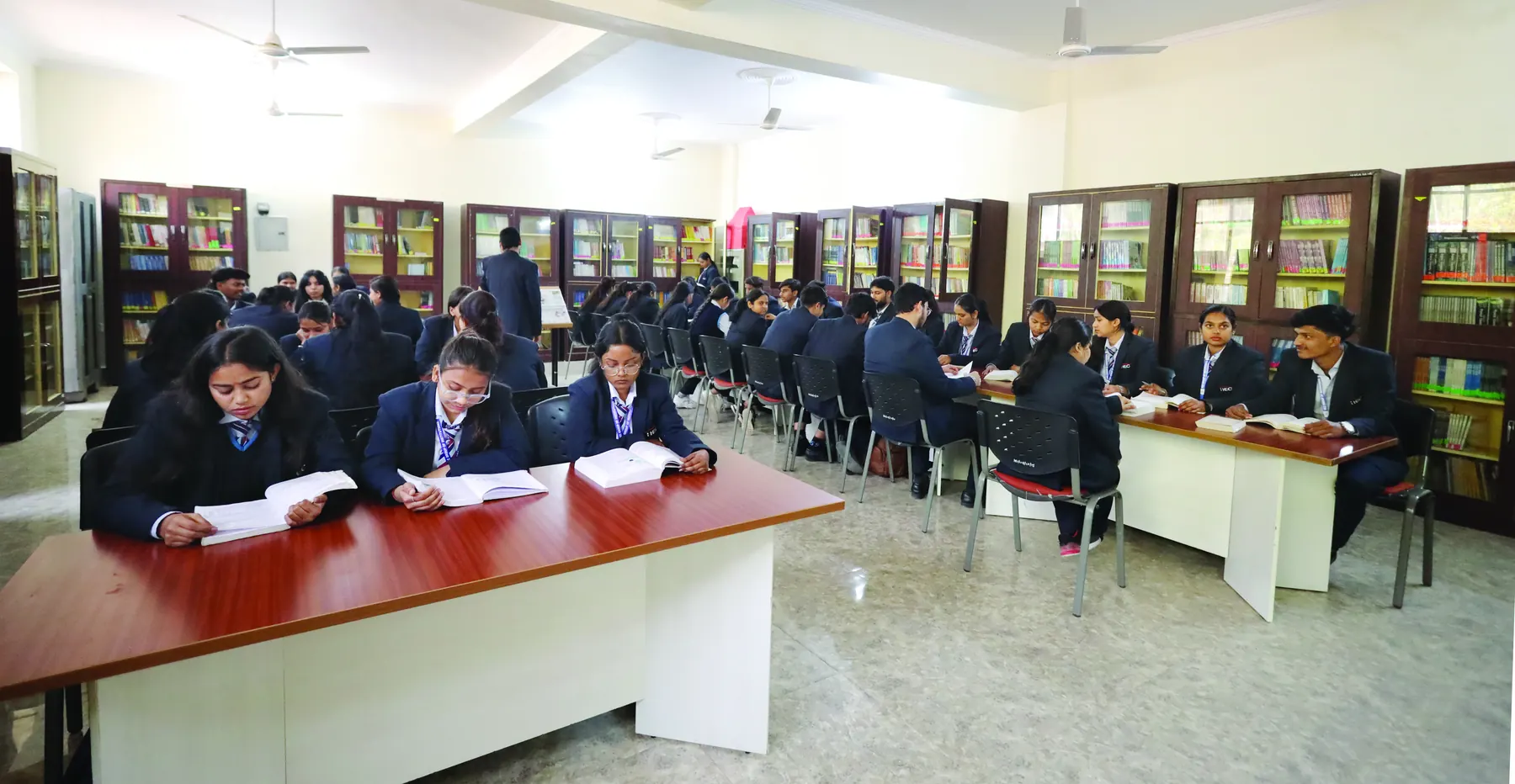 Students reading at long tables in the HEC library