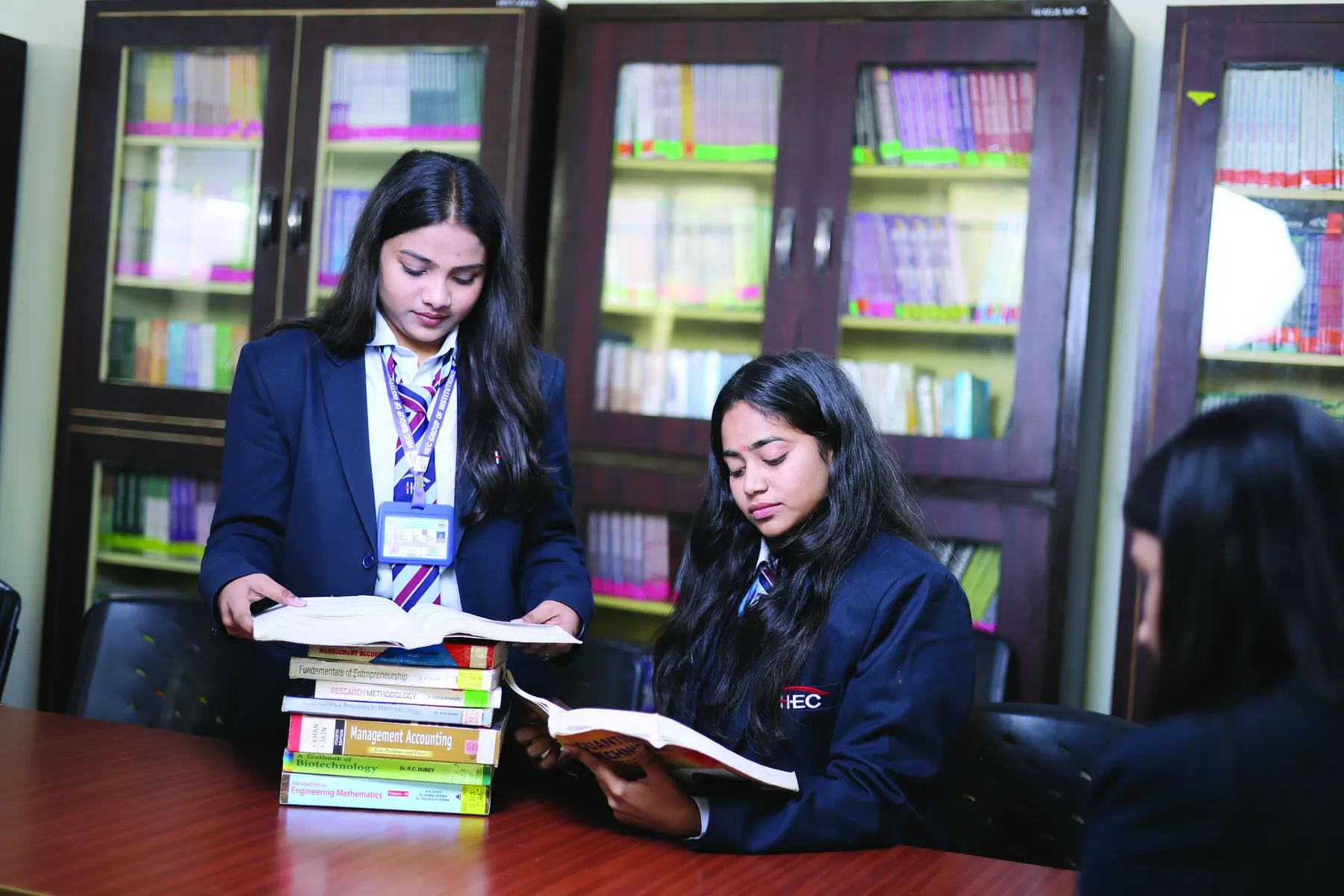 Students with a stack of books in the library
