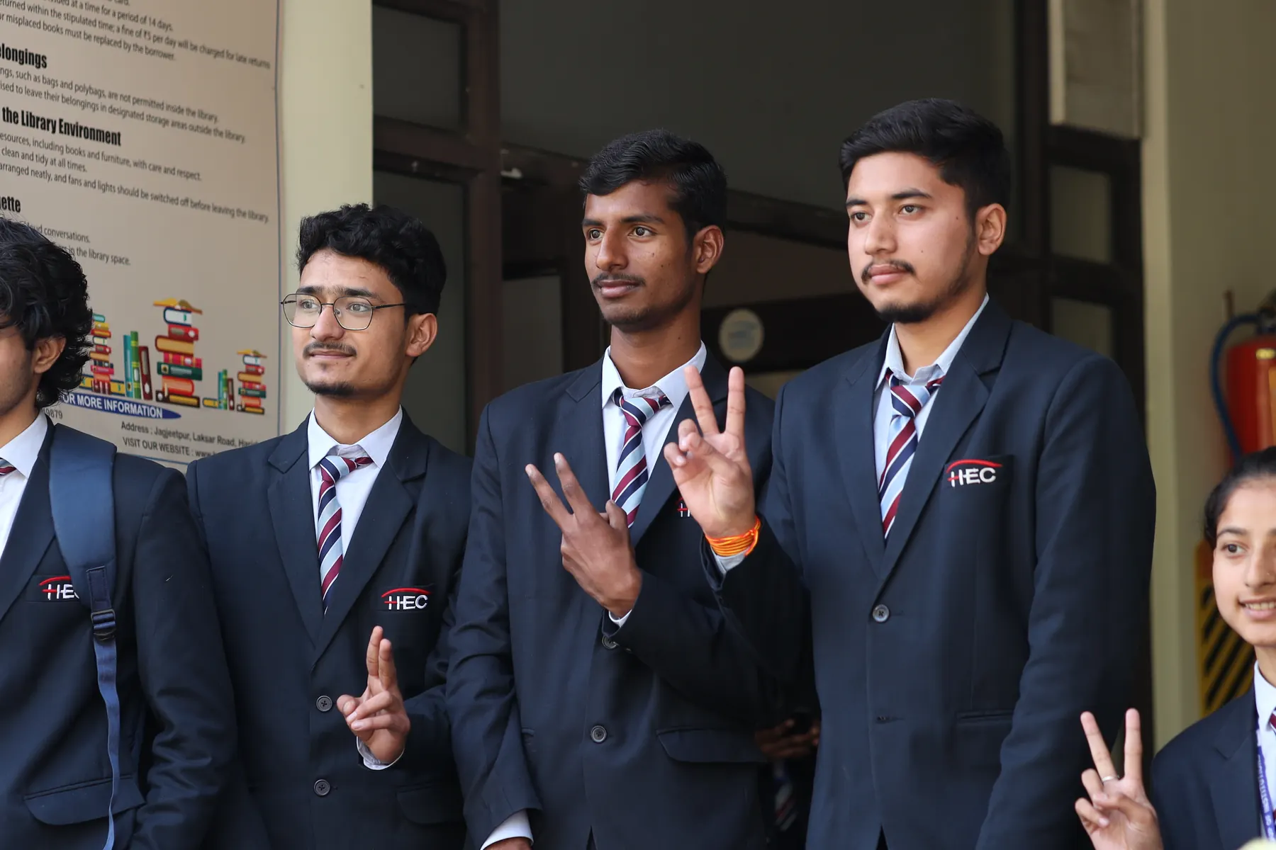 Students in HEC blazers smiling outside the library