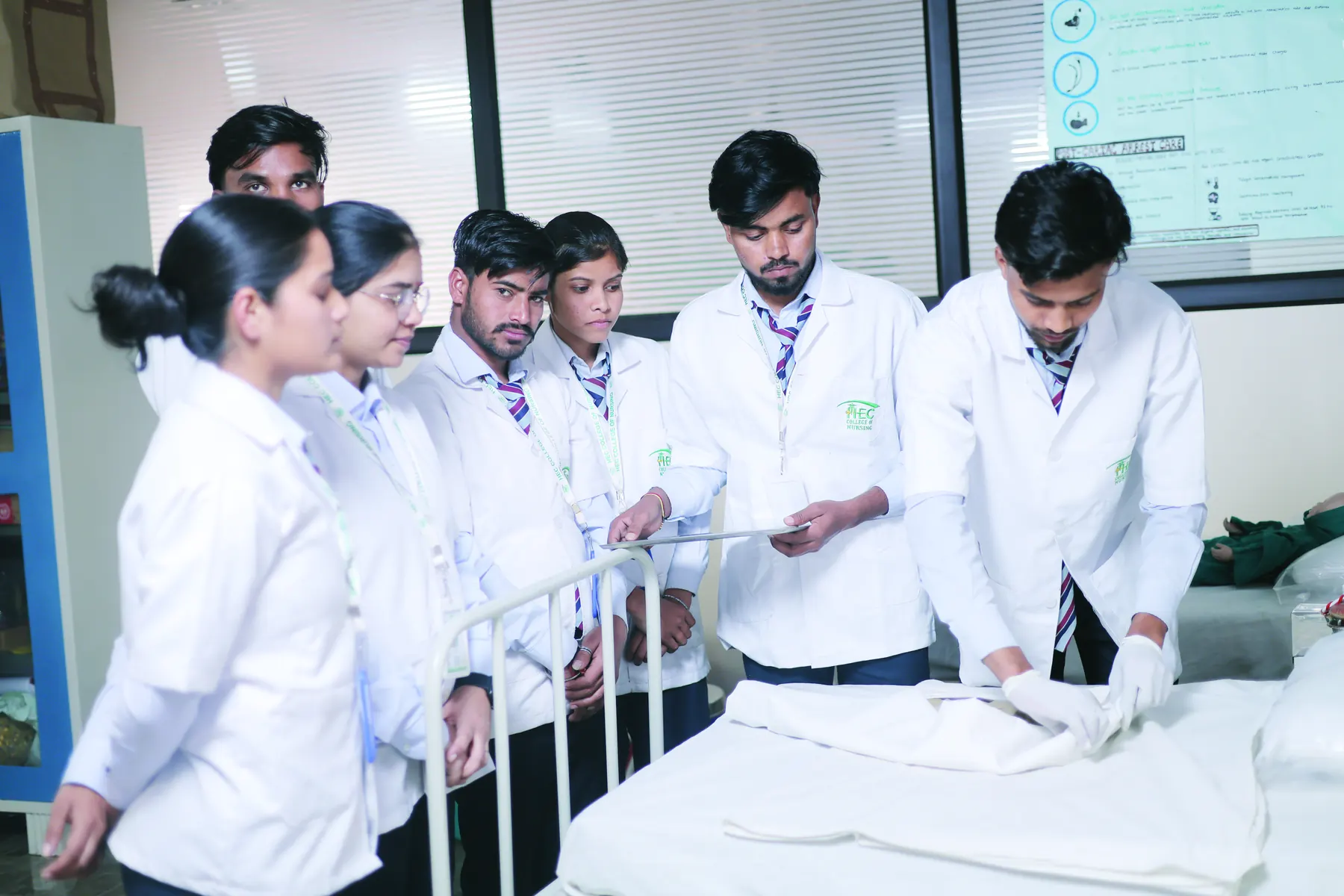 Nursing students practising bedside care in the nursing lab