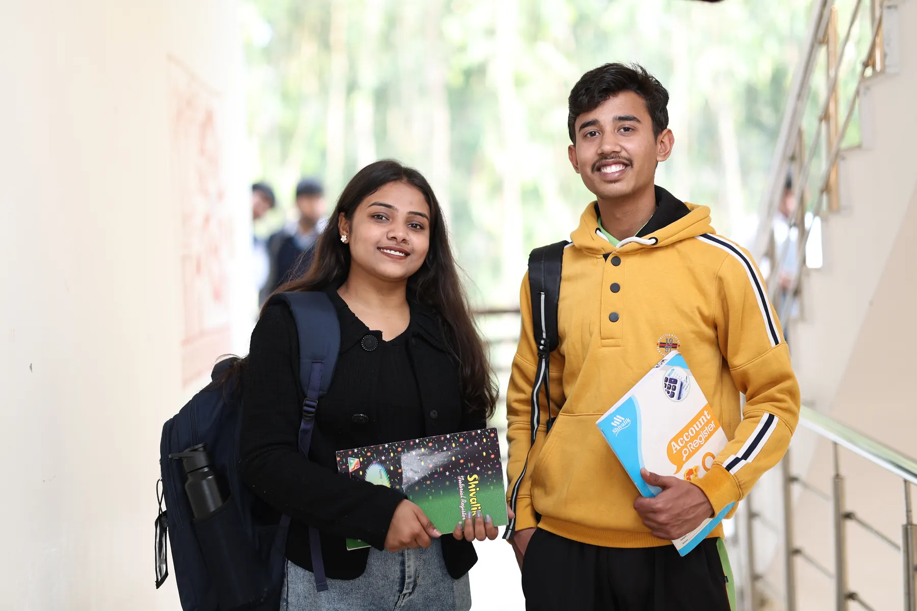 Two students with books on the campus stairway