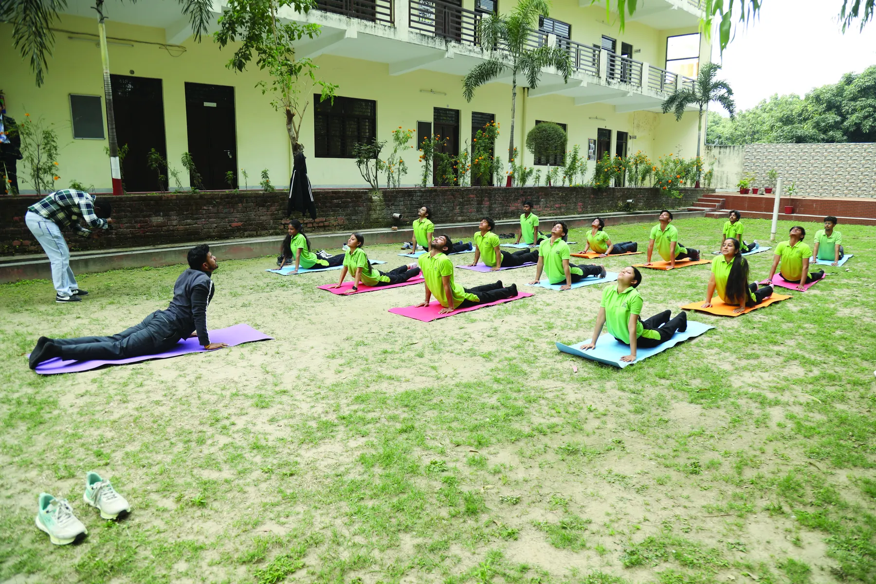 Students practising yoga on mats on the campus lawn